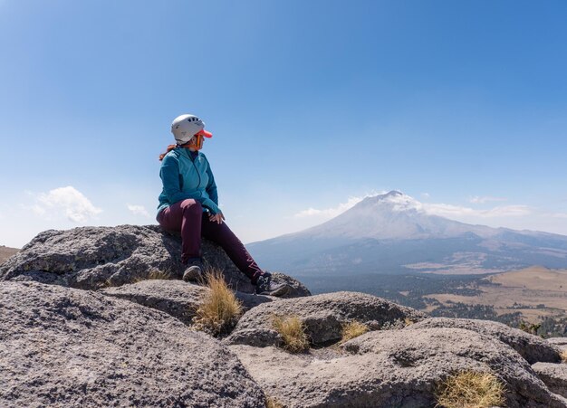 Caminante femenino que mira el volcán humeante