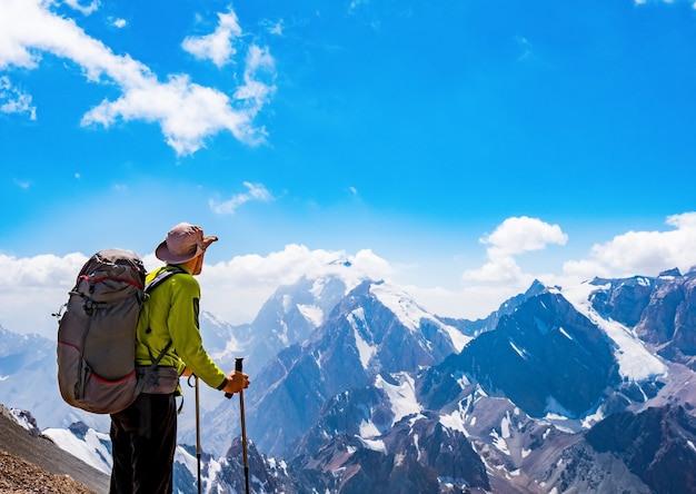 Caminante con mochila en la cima de una roca