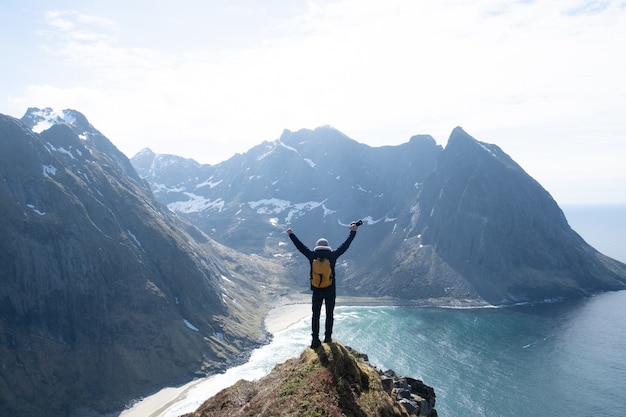 Caminante con mochila disfrutando del paisaje al atardecer en Lofoten, Noruega