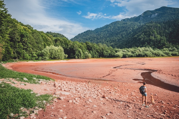 Caminante con un perro en el lecho del lago seco