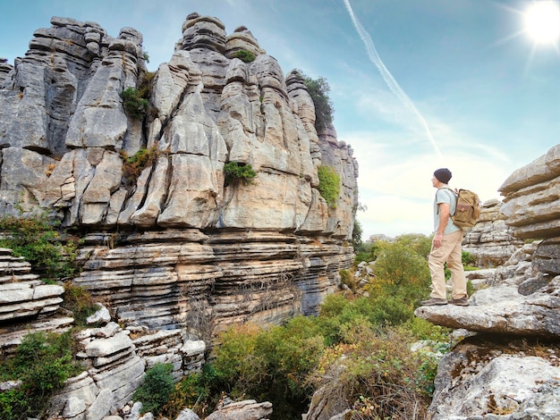 Caminante de pie sobre una roca con vistas a un paisaje rocoso Hombre senderismo Torcal de Antequera en España