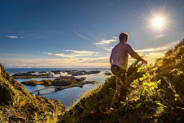 Caminante que va a la cima del monte festvagtinden en las islas lofoten