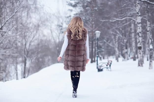 Caminar en un parque de invierno niña de navidad / hermosa modelo posando en la temporada de invierno caminar parque de la ciudad