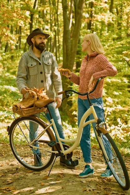Caminata de fecha de otoño en el bosque Pareja enamorada andar en bicicleta juntos en el parque forestal Cita romántica con bicicleta Hombre y mujer barbudos relajándose en el bosque de otoño Pareja romántica en cita Fecha y amor
