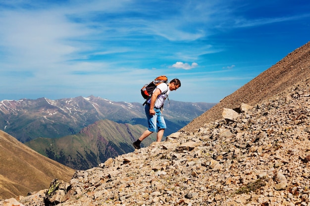 Caminata del hombre a la cima de la montaña, éxito, ganador, un hombre con una mochila se encuentra en la cima de la montaña. montañas de Karachay-Cherkessia.