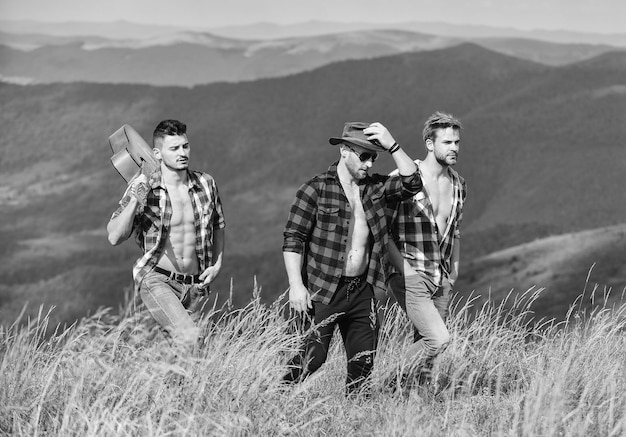 Caminata libre grupo de personas pasan tiempo libre juntos caminatas aventuras hombres vaqueros campamento occidental canciones de fogata hombres felices amigos con guitarra amistad hombres con guitarra en camisa a cuadros