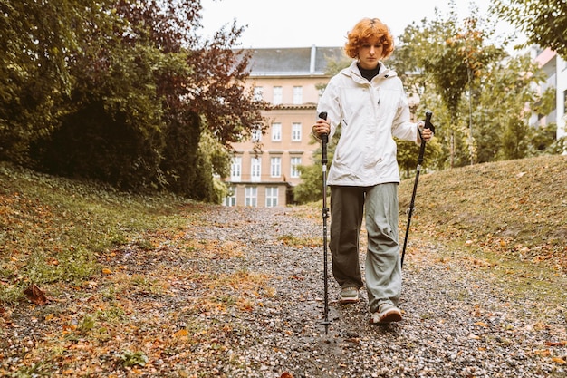 Foto caminata nórdica en el bosque de otoño caminata adolescente