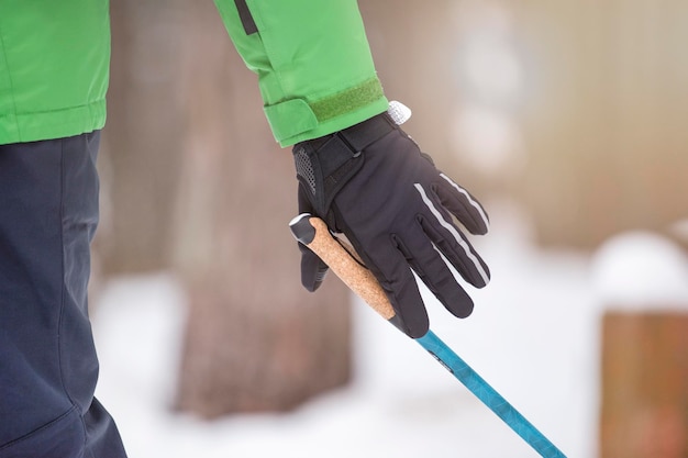 Caminata nórdica estilo de vida saludable deportes al aire libre en invierno la mano de un hombre aprieta el mango de un bastón