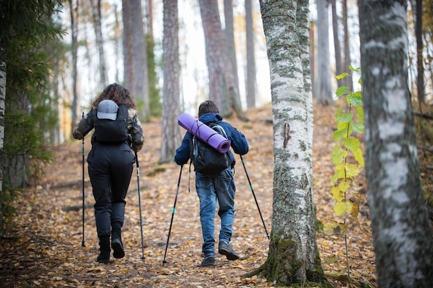 Caminata nórdica niño y mujer joven vista trasera bosque de abedules