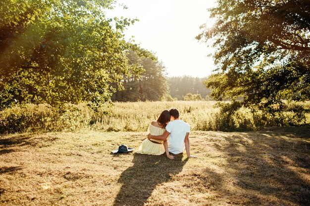 Camine una pareja joven feliz en la naturaleza fuera de la ciudad