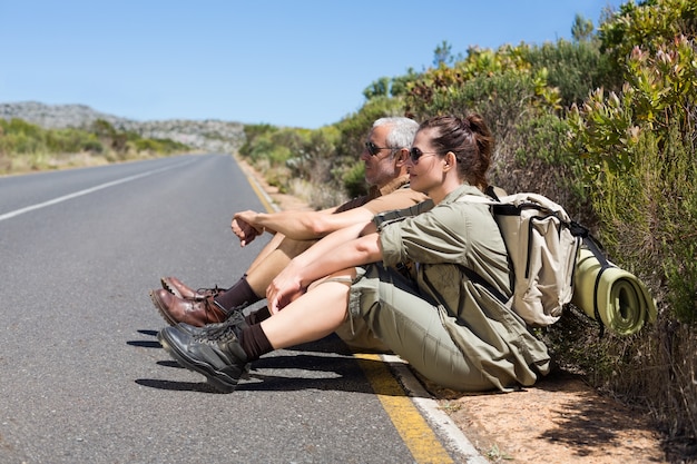 Caminhada casal sentado ao lado da estrada