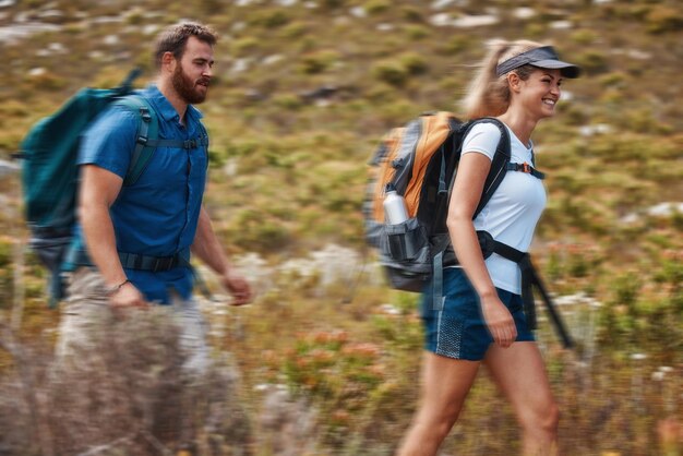 Caminhadas em movimento borrado e aventura com um casal na montanha para exercícios de saúde ou fitness juntos Treinamento na natureza e amor com um homem e uma mulher caminhando nas montanhas enquanto se unem