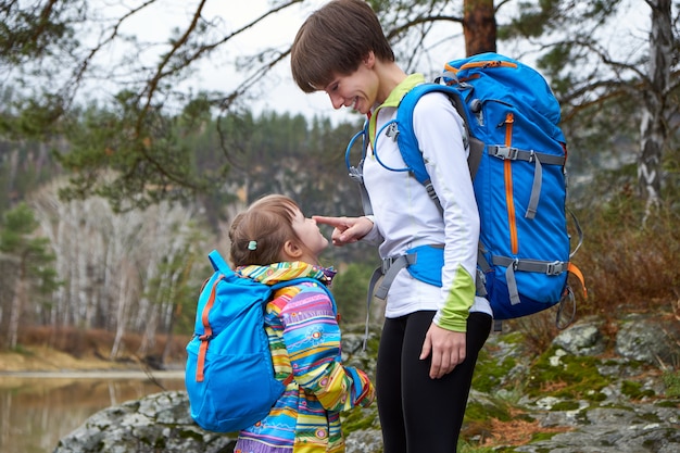 Caminhadas feliz mãe e filha viajando com mochilas