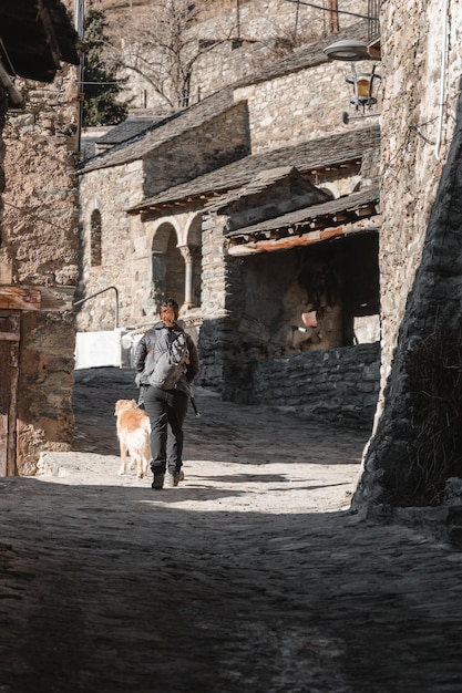 Caminhando menina com seu cachorro em uma cidade nos Pirenéus