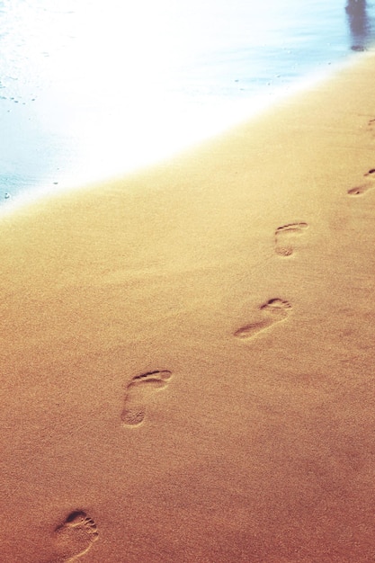 Caminhando na praia deixando pegadas na areia