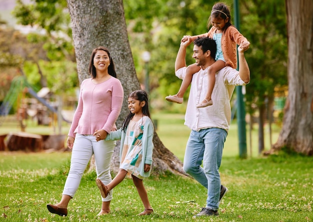 Caminhando nas costas e família feliz em um parque conversando e se unindo com sorriso de amor e diversão na natureza Crianças pais e conversando na floresta juntos no fim de semana alegre e desfrutando da liberdade