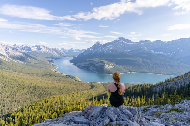 Caminhante apreciando a vista do belo vale alpino e do lago nas montanhas rochosas canadenses cume do rimwall