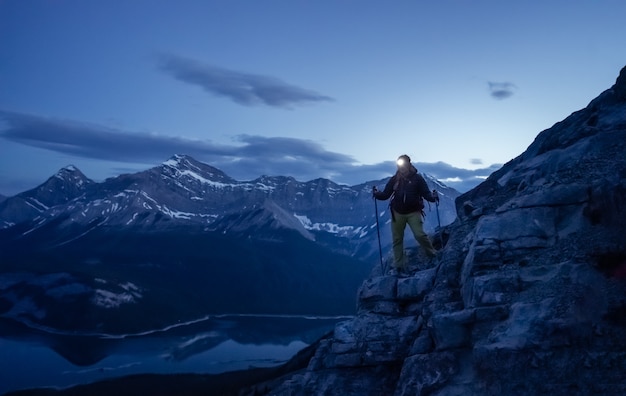 Caminhante descendo a montanha durante a noite com farol brilhante rimwall cume canadá