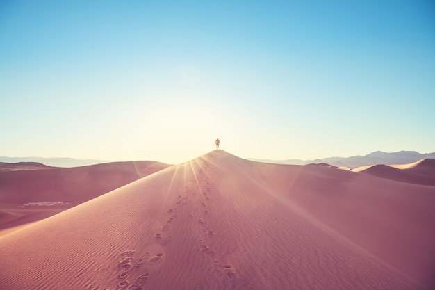 Caminhante entre dunas de areia no deserto