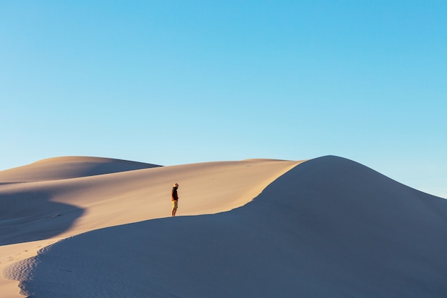 Caminhante entre dunas de areia no deserto