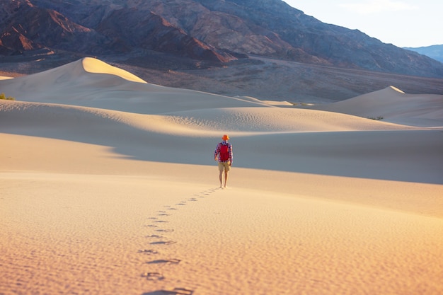 Caminhante entre dunas de areia no deserto