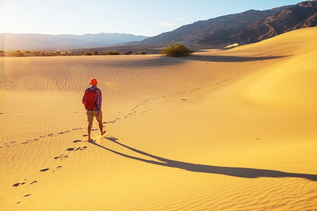 Caminhante entre dunas de areia no deserto