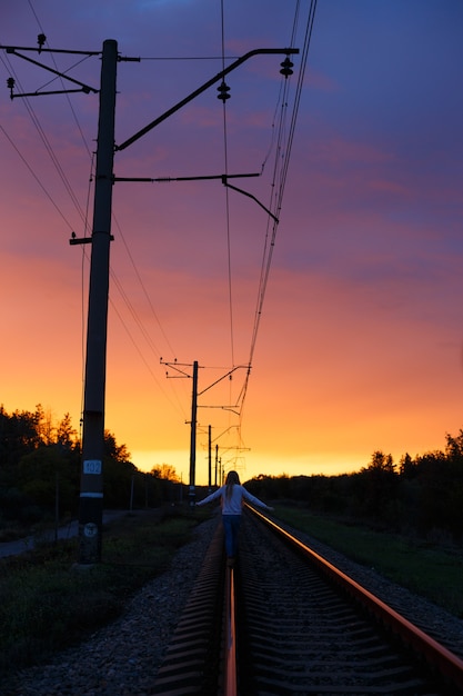 Foto caminhante na estrada de ferro na luz do sol