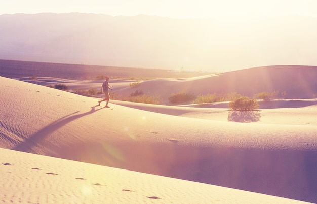 Foto caminhante no deserto de areia. hora do nascer do sol.