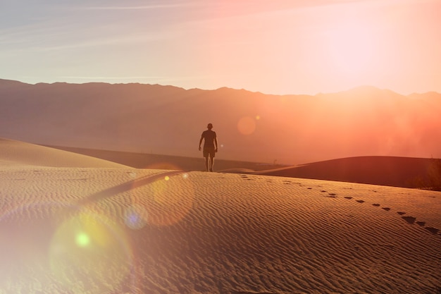 Foto caminhante no deserto de areia. hora do nascer do sol.