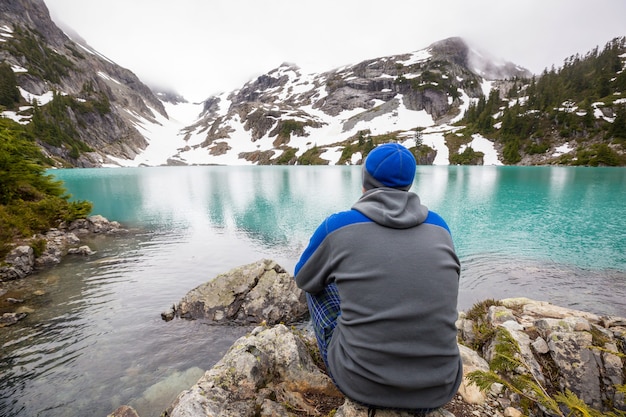 Caminhante relaxando em um lago sereno na montanha