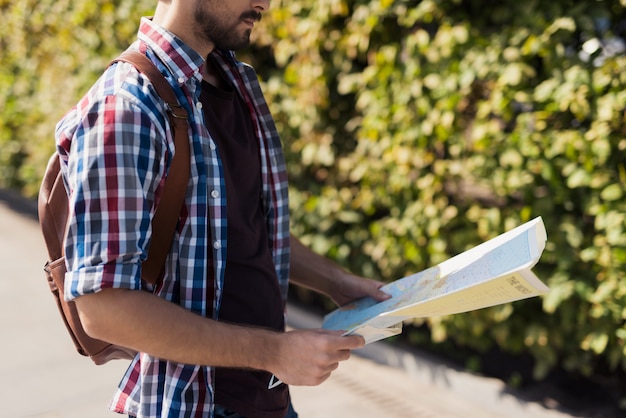 Caminhante solitário está estudando um mapa planejando uma rota.