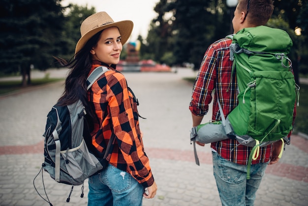 Caminhantes com mochilas viajando por cidade turística