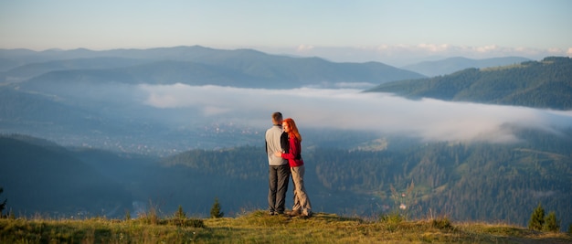 caminhantes do casal apreciando a paisagem de montanha