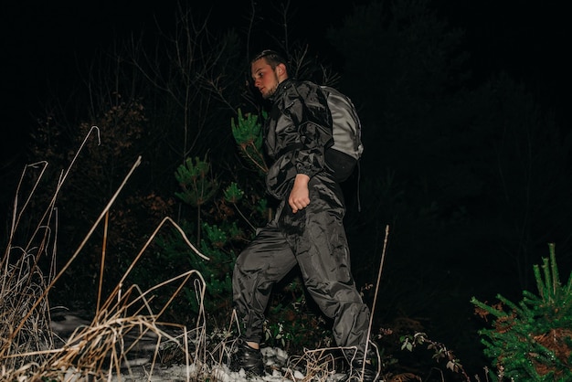 Caminhantes masculinos em roupas para caminhadas e lanternas na montanha de inverno à noite.