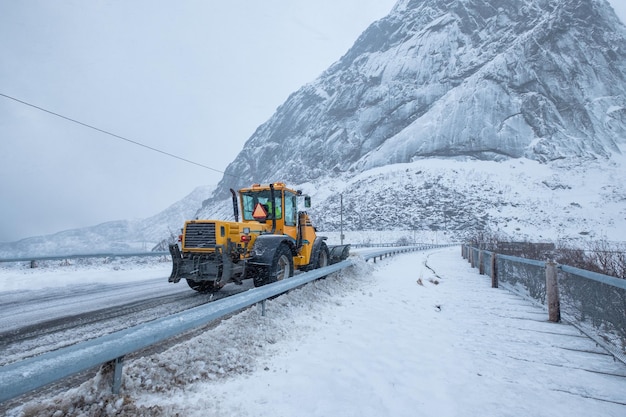 Caminhão de arado de neve limpando neve na estrada no subúrbio durante forte tempestade de neve