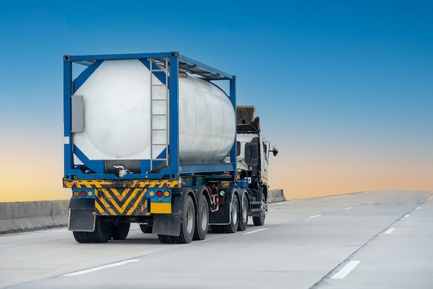 Foto caminhão de gás na estrada da rodovia com recipiente de óleo do tanque, conceito de transporte., importação, exportação logística industrial transporte transporte terrestre na via expressa com céu azul. borrão de movimento da imagem