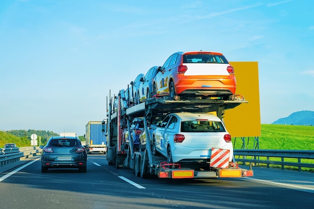 Caminhão de transporte de carros na estrada asfaltada da Eslovénia. Transportador de caminhão