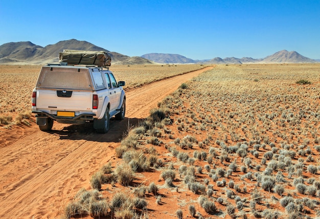 Foto caminhão dirigindo na estrada deserta em direção às montanhas tiras