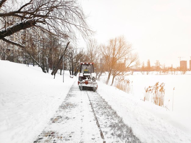 Caminhão removedor de neve trator de inverno limpando ruas da cidade estradas de neve queda de neve clima extremo