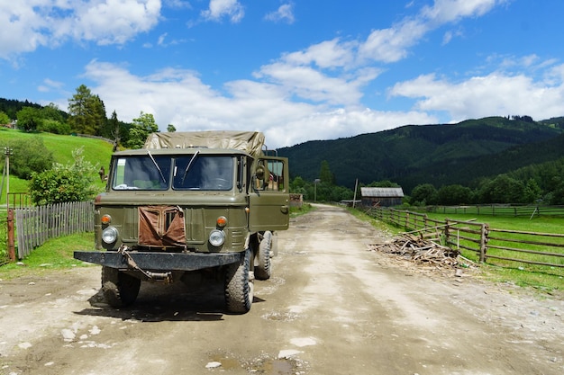 Caminhão verde militar soviético velho poderoso pesado na estrada da estrada das montanhas do país Fundo do conceito de sobrevivência horizontal