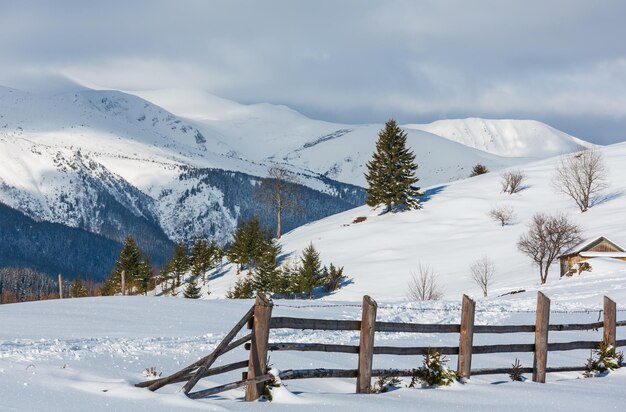 Caminho coberto de neve rural da montanha da manhã do inverno