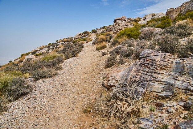 Caminho de caminhada através de colina íngreme com pedras no deserto