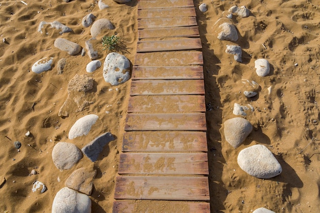 Caminho de madeira na areia para o mar