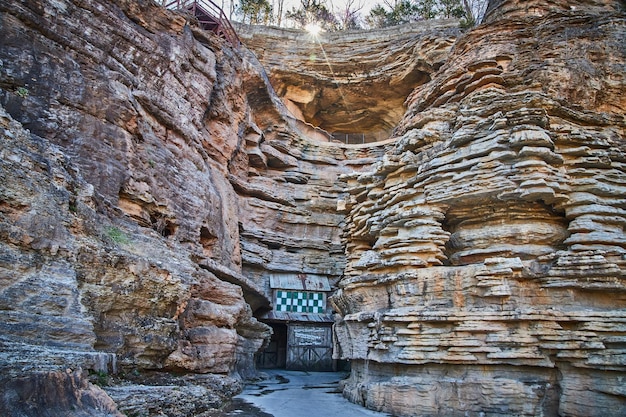 Caminho pavimentado em uma caverna repleta de camadas de rochas em penhascos