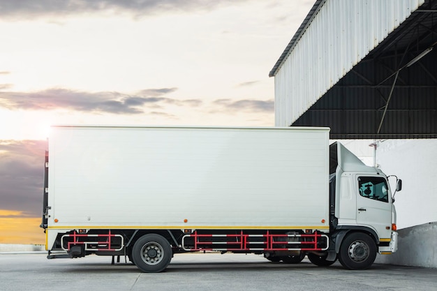 Caminhões de carga estacionados no armazém com a logística de carga de caminhões de contêineres Sunset Sky
