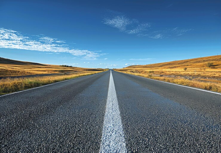 Un camino abierto que se extiende hacia el horizonte bajo un cielo claro y expansivo esta escena simboliza infinitas posibilidades ideal para agregar citas motivacionales sobre la aventura y el movimiento hacia adelante