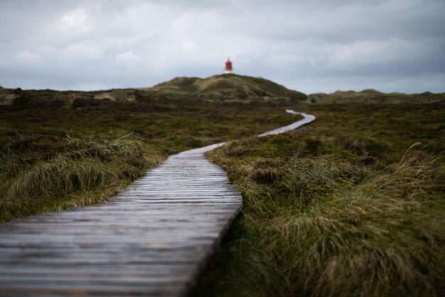 Foto camino al faro en la isla de amrum alemania después de la lluvia en un día nublado