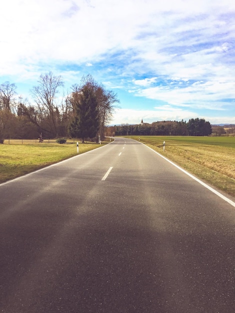 Camino por los árboles contra el cielo