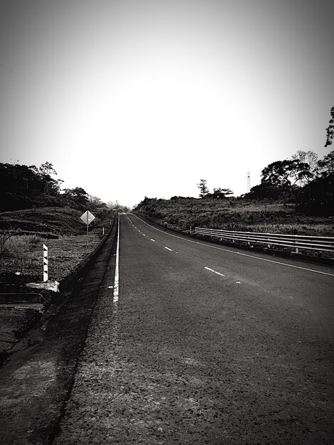 Foto camino de campo por campo contra un cielo despejado