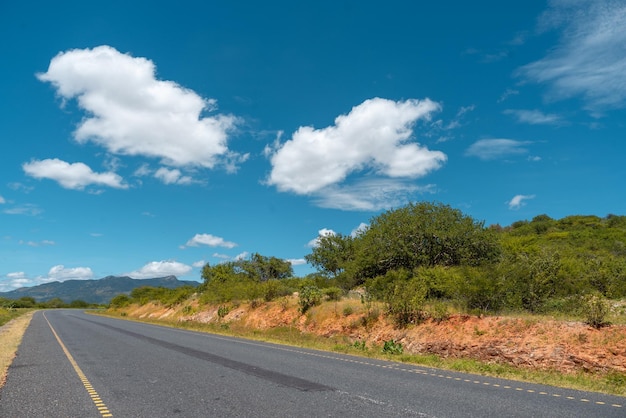 Un camino con un cielo azul y nubes